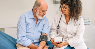 Latin female physician measuring a patient's blood pressure on a gurney stock photo